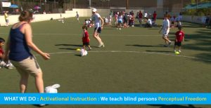 Page banner shows a soccer clinic inside a walled-in outdoor soccer and field hockey field. Blind children and teens are learning soccer shill using soccer balls wrapped in plastic bags for audability. The text band reads: What We Do: Activational Navigation: We teach blind persons Perceptual Freedom.