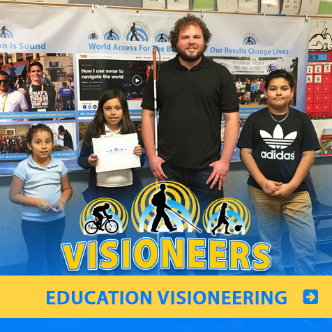 Category link: Education Visioneering. Visioneer Brian Bushway is pictured with three students at a Los Angeles primary school.