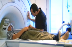 Lead Visioneer Daniel Kish lying on an MRI gurney being loaded into position.