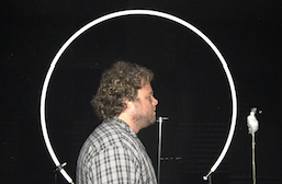 WAFTB Perceptual Navigation Instructor Brian Bushway participates in echolocation research and is shown standing nect to circular metal tubing and a microphone.
